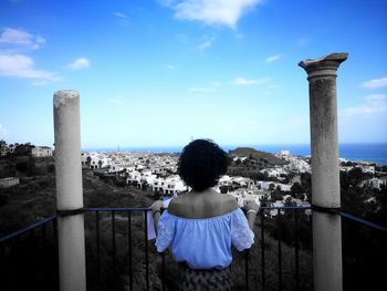 Rear view of woman looking at sea against sky