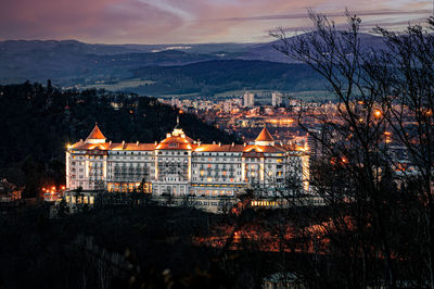 Illuminated buildings against sky at sunset