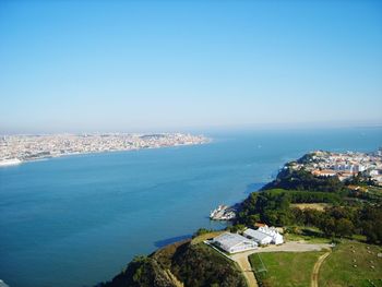 High angle view of buildings by sea against clear sky