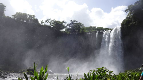 Scenic view of waterfall against sky