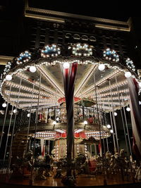 Low angle view of illuminated carousel at night