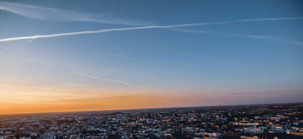 Aerial view of illuminated buildings in city against sky during sunset