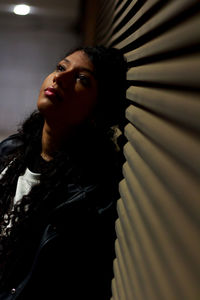 Thoughtful woman leaning on shutter