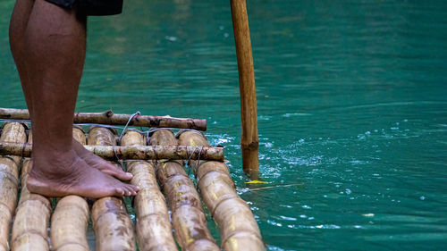 Low section of man standing in lake