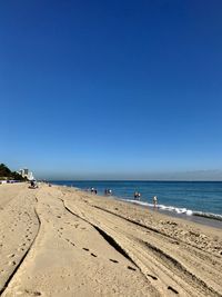 Scenic view of beach against clear blue sky