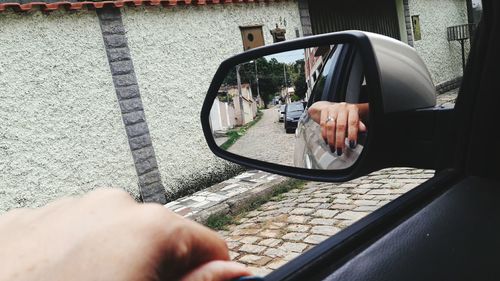 Man holding smart phone by car window