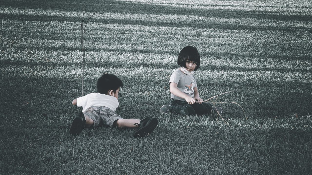 child, childhood, grass, men, two people, casual clothing, togetherness, full length, sitting, black, toddler, nature, day, leisure activity, high angle view, plant, female, women, lifestyles, family, outdoors, bonding, field, friendship, emotion, innocence, baby, white, land