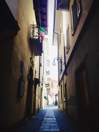 Alley amidst houses against sky