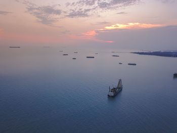 Sailboats in sea against sky during sunset