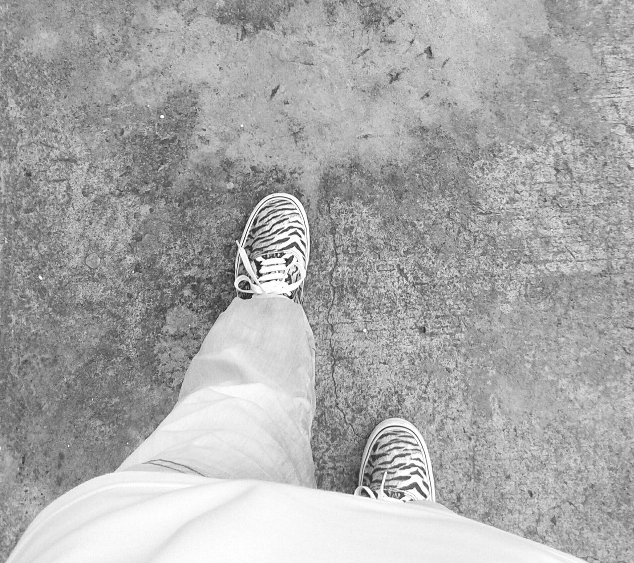 low section, person, shoe, personal perspective, human foot, footwear, high angle view, standing, jeans, lifestyles, leisure activity, men, directly above, unrecognizable person, part of, canvas shoe, outdoors