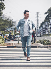 Full length of young man crossing road