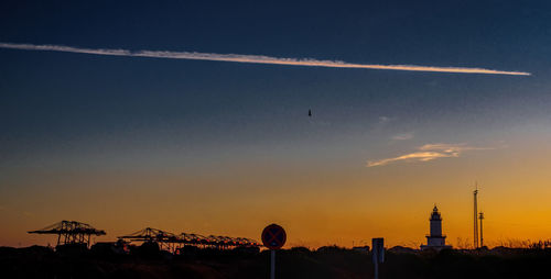 Scenic view of vapor trails in sky during sunset