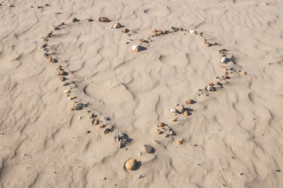 High angle view of heart shape on sand