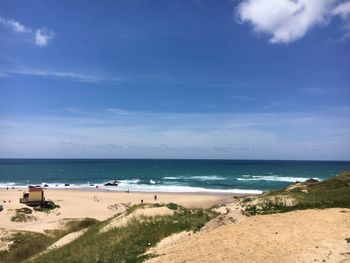 Scenic view of beach against blue sky