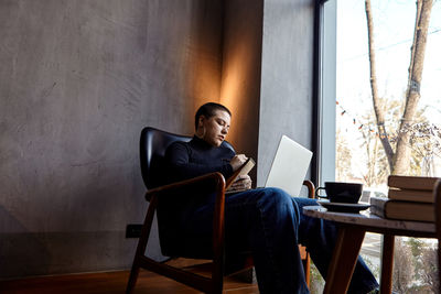 Low section of woman using laptop at home