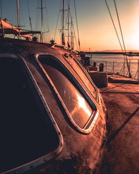 Cars on sea against sky during sunset