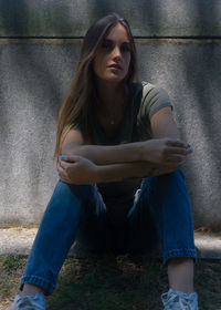 Portrait of young woman sitting on field