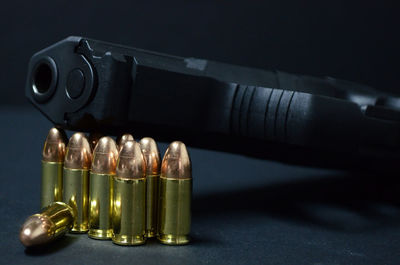 Close-up of bullet with handgun on table