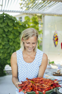 Mature woman holding bowl of crayfish