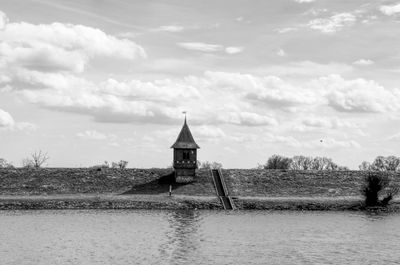 Scenic view of river by building against sky