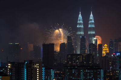 Illuminated petronas towers and fireworks at night