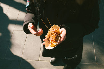 Midsection of man holding umbrella