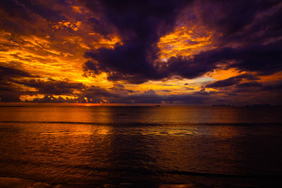 Scenic view of sea against dramatic sky during sunset