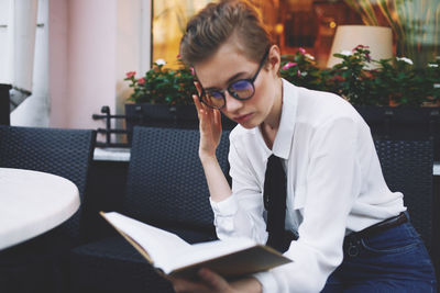 Young woman sitting on book