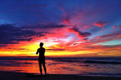 Silhouette of people on beach at sunset