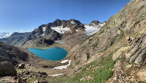 Scenic view of lake and mountains against clear blue sky