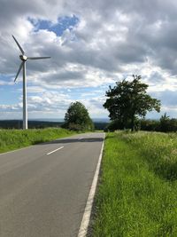 Road by field against sky