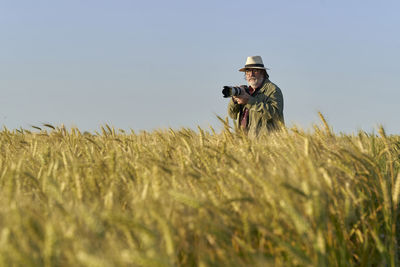 Rear view of woman walking on field against sky