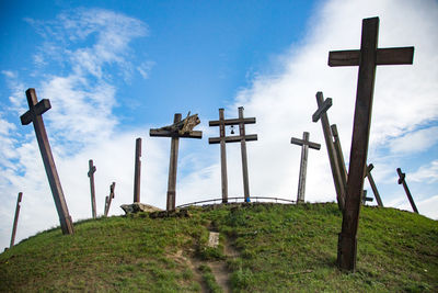 View of cross on landscape against blue sky