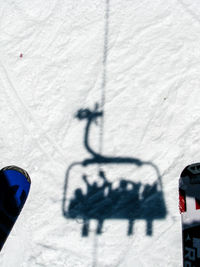 Shadow of people in ski lift on snow