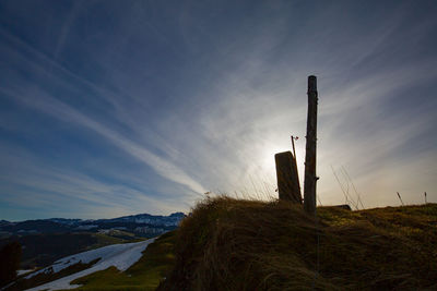 Windmills on landscape against sky during sunset