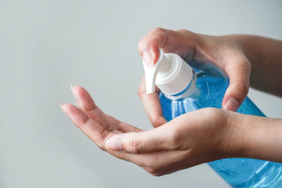 Close-up of woman holding hands over white background