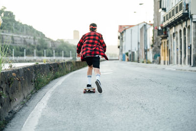 Rear view of man riding motorcycle on road