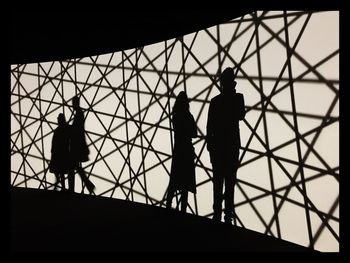 Shadow of people on illuminated patterned wall