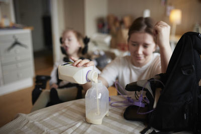 Mother preparing nutrition for feeding tube for disabled child