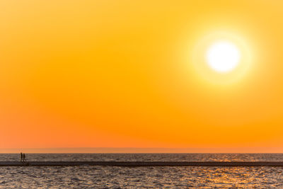 Scenic view of sea against orange sky