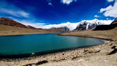 Scenic view of lake and mountains against blue sky