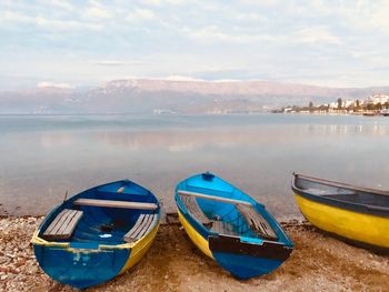 Boats moored on beach against sky