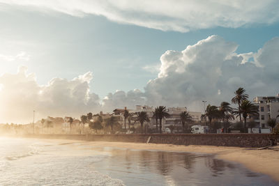 Panoramic view of people on beach against sky