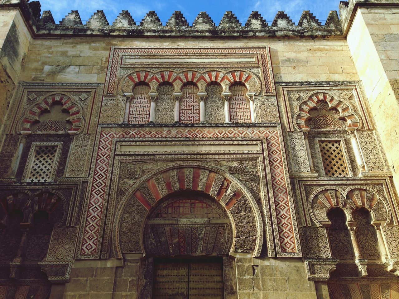 architecture, building exterior, built structure, low angle view, arch, history, window, art and craft, facade, art, ornate, human representation, statue, old, sculpture, carving - craft product, architectural column, day, creativity, outdoors