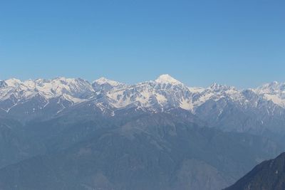 Scenic view of snowcapped mountains against clear blue sky