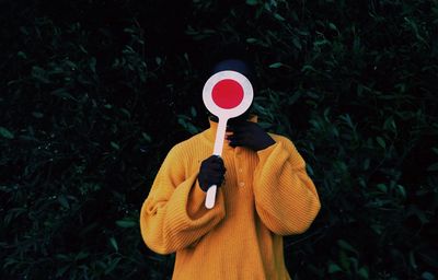 Man holding umbrella standing by plant