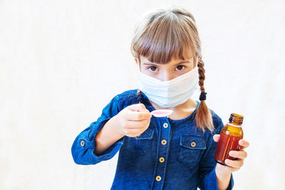 Portrait of girl holding medicine bottle