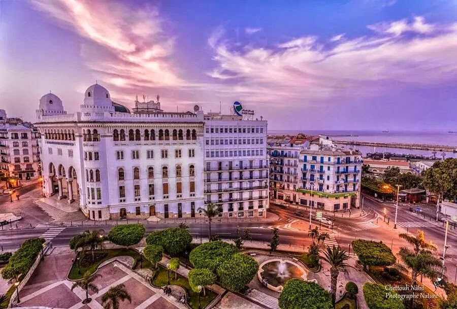 building exterior, architecture, built structure, sky, city, tree, cloud - sky, residential building, high angle view, residential structure, cityscape, sunset, building, residential district, street, incidental people, city life, outdoors, cloud, travel destinations