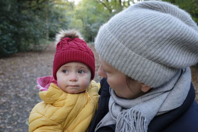 Close-up of woman holding crying son on road