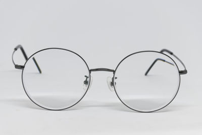 Close-up of eyeglasses on table against white background